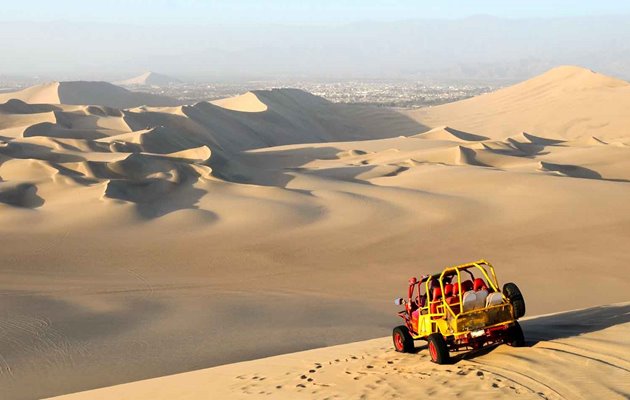 Du kan sandboarde eller køre buggy-biler i de enorme sandklitter ved Ica